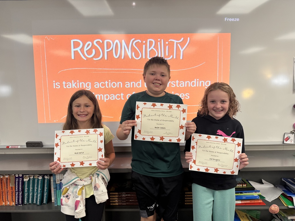 Three students standing in front of a whiteboard with responsibility showing with each student holding a certificate.