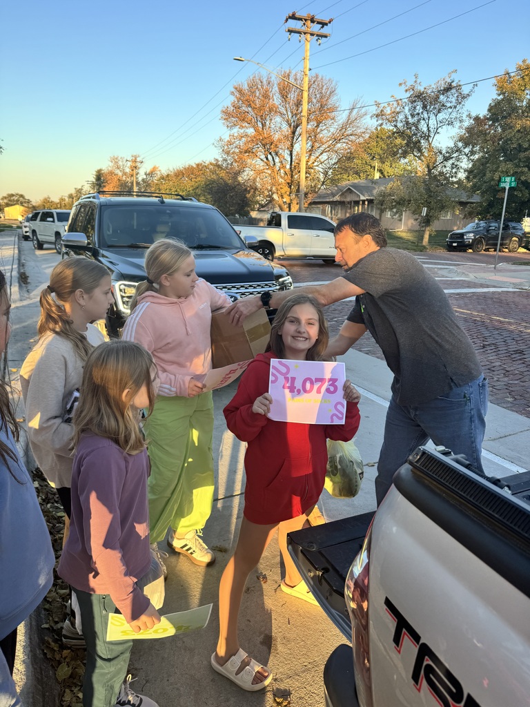 Group of children holding boxes that are being handed to an adult with a sign that shows the number 4,073