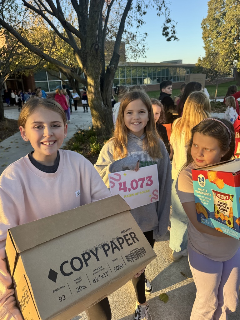 Group of children holding boxes that are being handed to an adult with a sign that shows the number 4,073