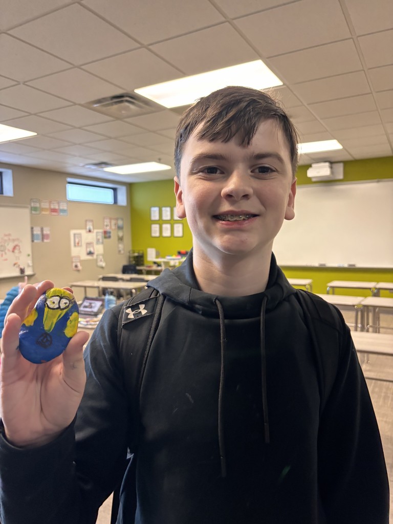 Photo of a student holding a rock with a minion character painted on it.