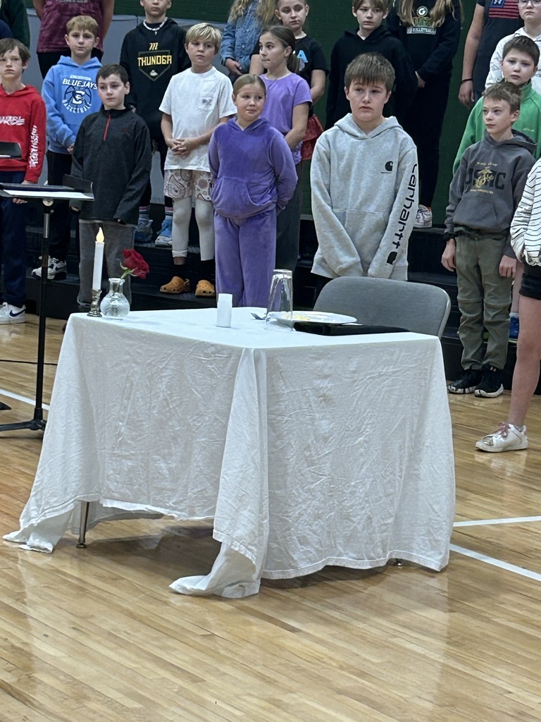 Chair seated a table with a white tablecloth with a plate and drink and silverware set out.