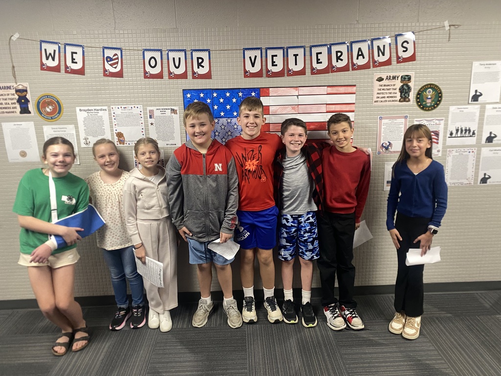Group of students standing in front of a wall that says We Love Our Veterans