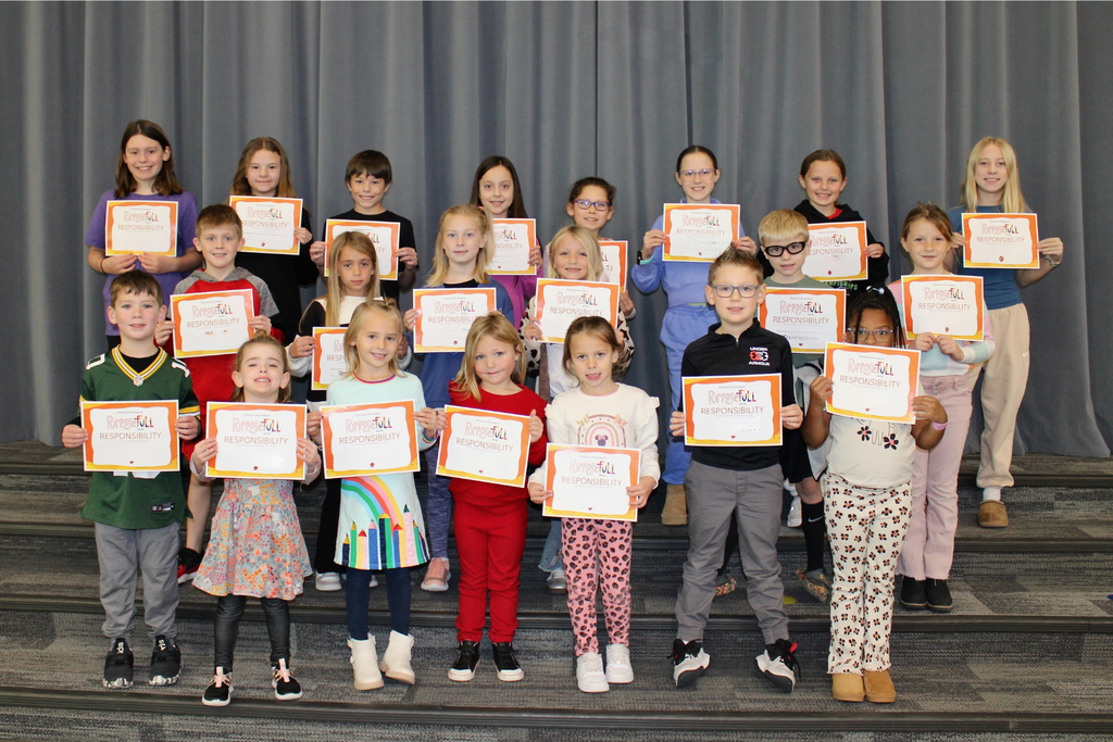 Three rows of students holding their signs for being the Student of the Month who demonstrated Responsibility.