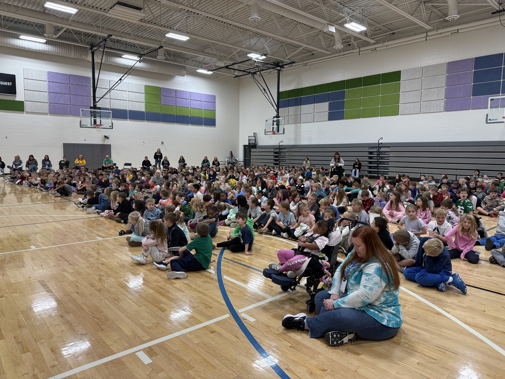 Students sitting on the gym floor in rows for our all school assembly.