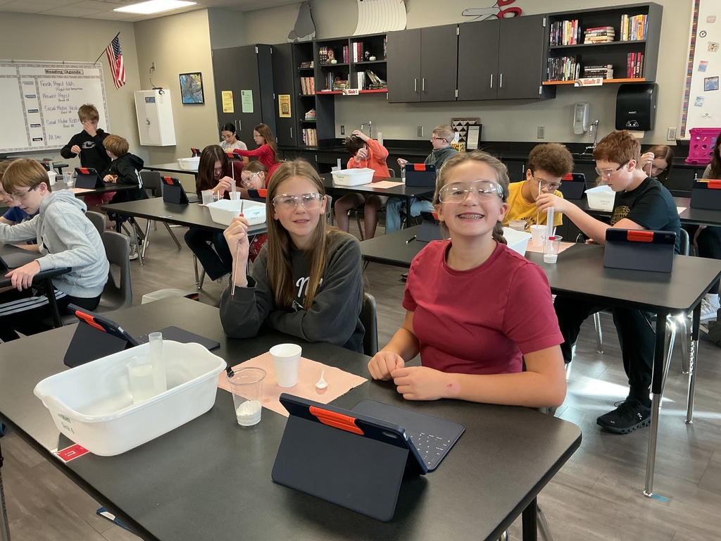 Photo of two students smiling while working on a lab experiment.