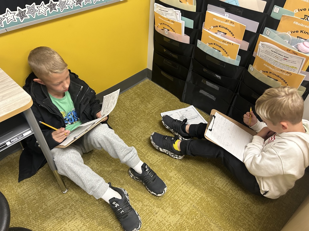 students work on a project on the floor of a classroom