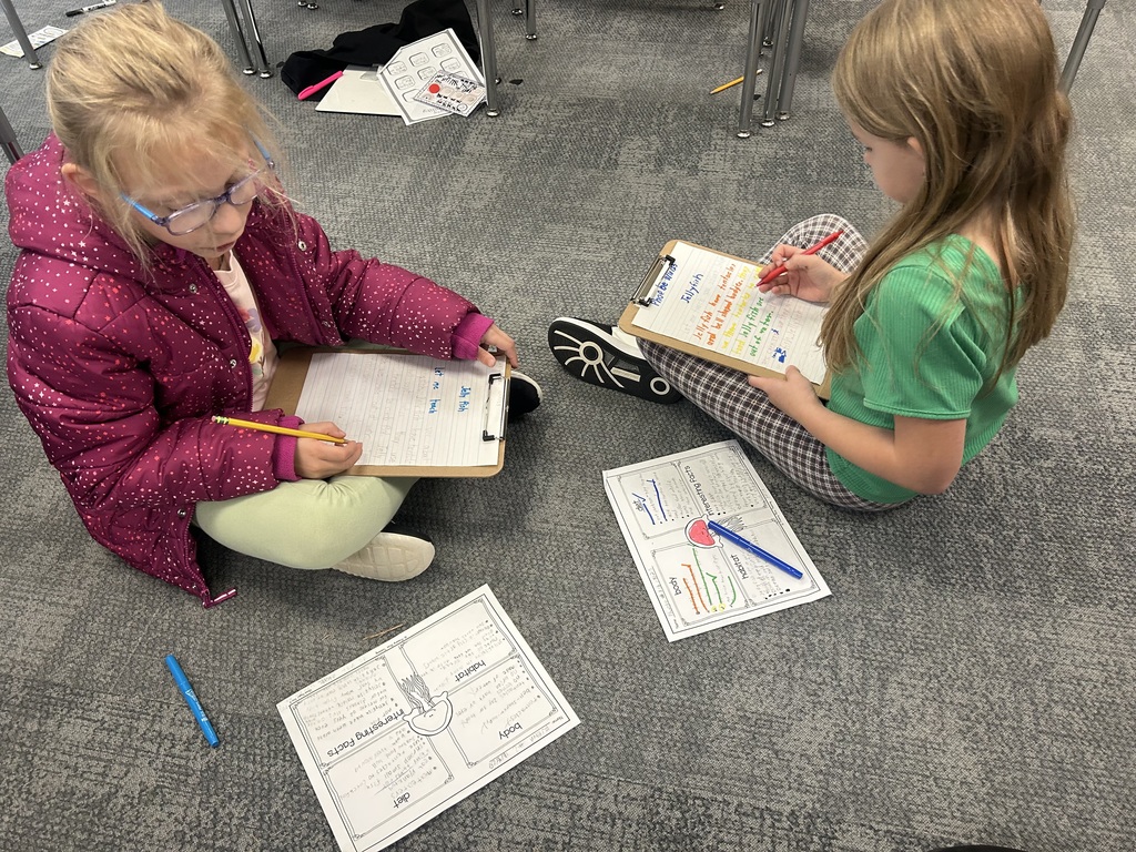 students work on a project on the floor of a classroom
