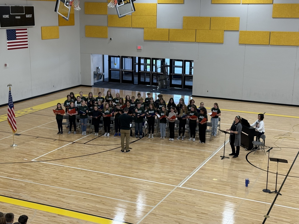 Photo of the GCMS choir singing a song in the gym at the assembly.