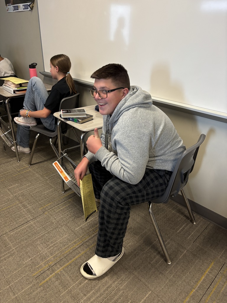 Photo of a student holding his registration paper and giving the camera a thumbs up.