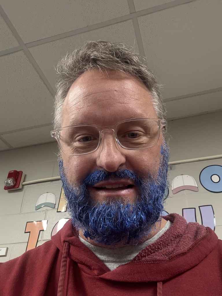 Man smiling wearing glasses while sporting a blue beard.