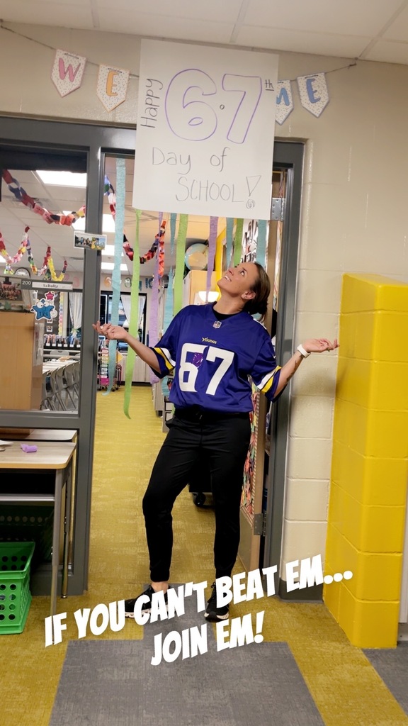 Teacher posing under a sign