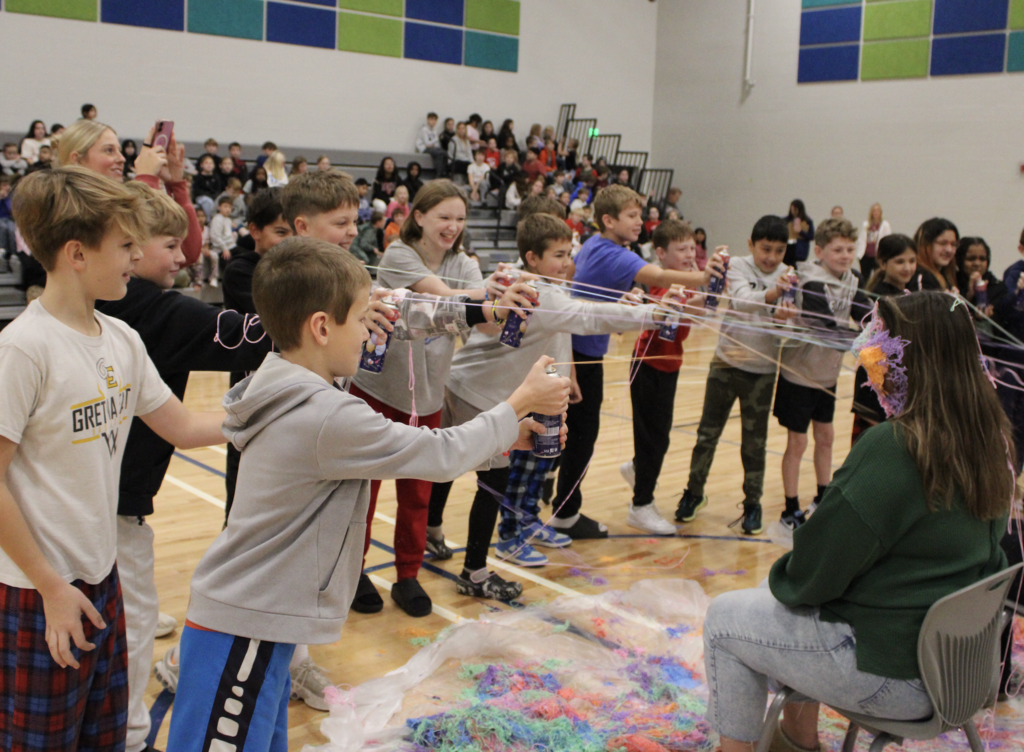 Mrs. Michka takes in a face full of silly string from her fifth graders.