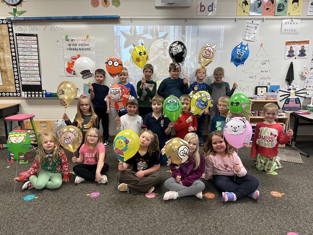 First grade students smiling with parade balloons