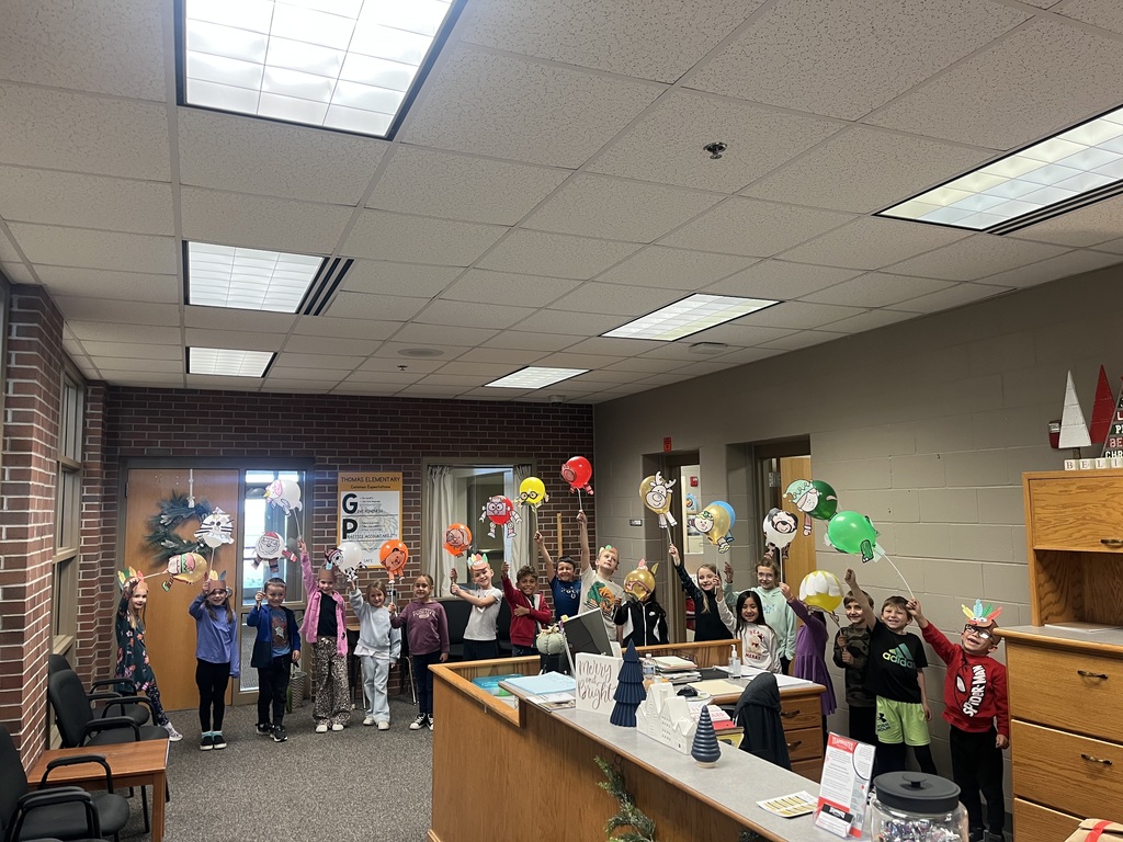 First grade students showing off their Thanksgiving parade balloons in the office