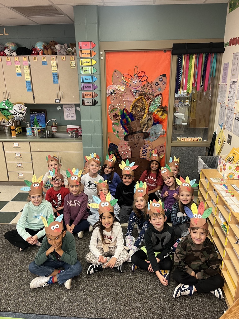 First grade students smiling with turkey hats on