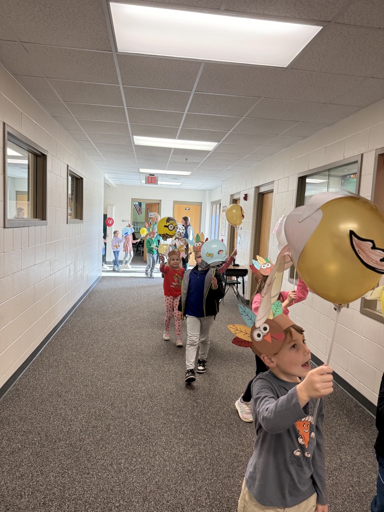First grade students parading through the halls with their balloons