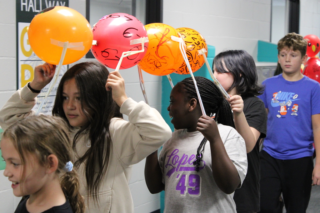 A team of 3rd and 5th grade girls carry their balloons together. 