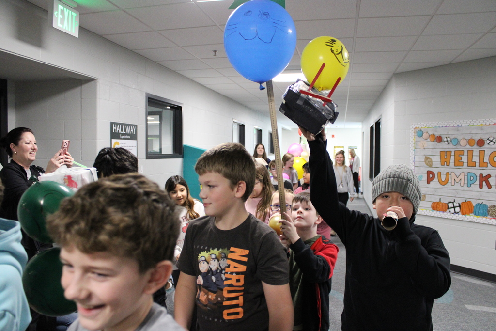 Students carry balloons together as they walk in the parade. 