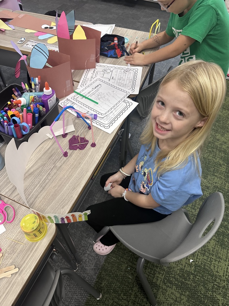 student working and smiling at their desk