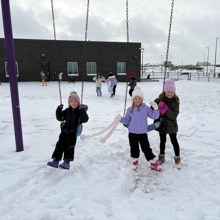 three girls bundled up are on the swings