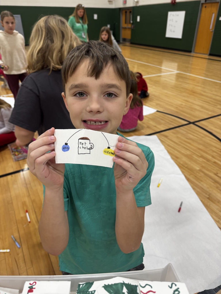 Boy holding a coffee sleeve that is decorated for Christmas.
