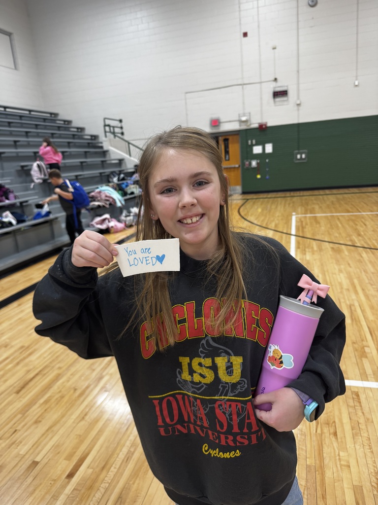 Girl holding a coffee sleeve that says You are Loved.