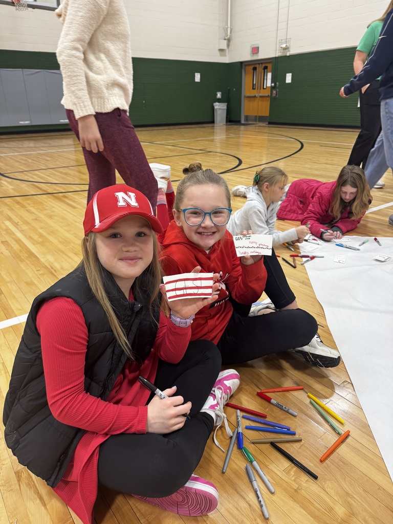 Girls holding a coffee sleeve that is decorated for Christmas.