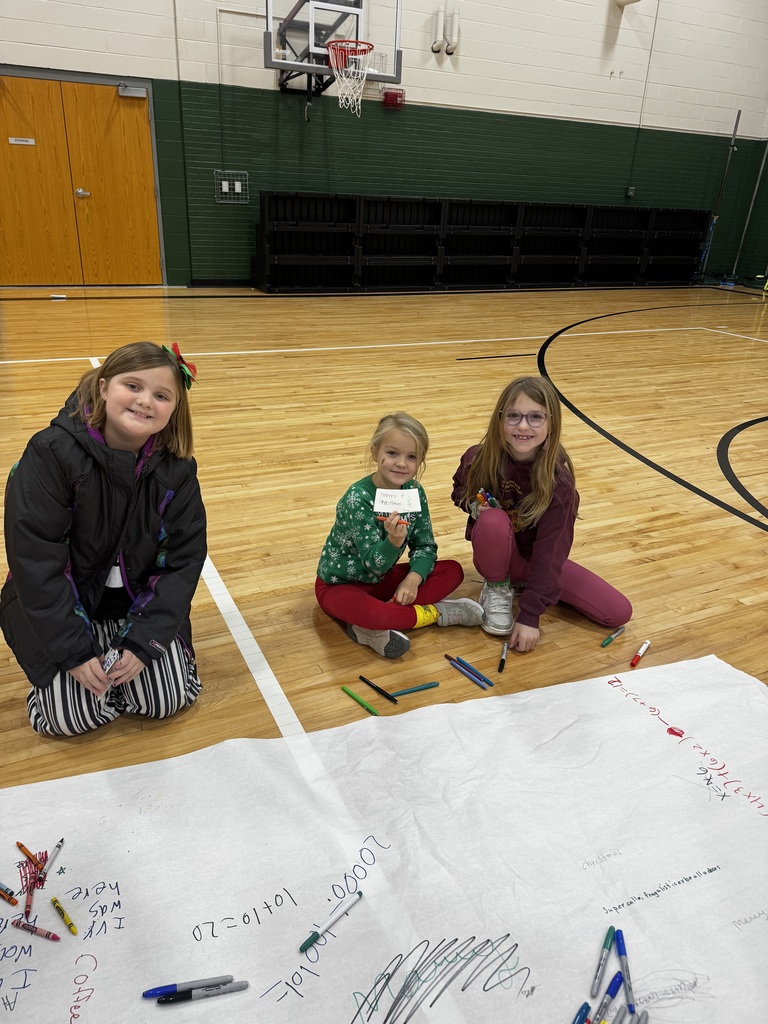 Girls holding a coffee sleeve that is decorated for Christmas.