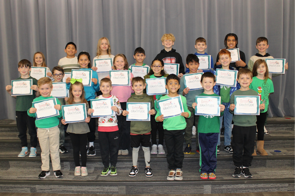 Three rows of students holding their signs for being the Student of the Month who demonstrates Gratitude.