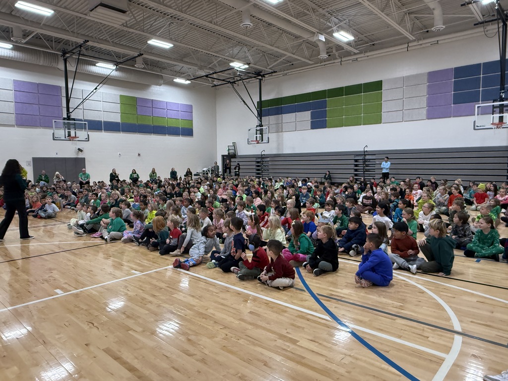 A gym of students is sitting  facing the front for our student of the month assembly.
