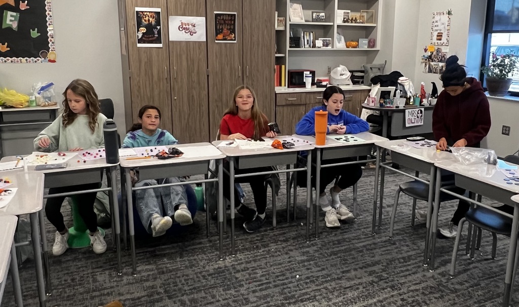 A group of five student sit at desks playing bingo.