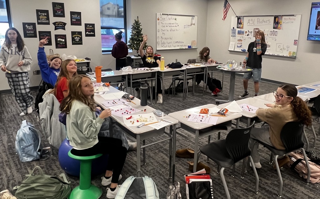 Students sit at desks in a U-shape playing bingo.