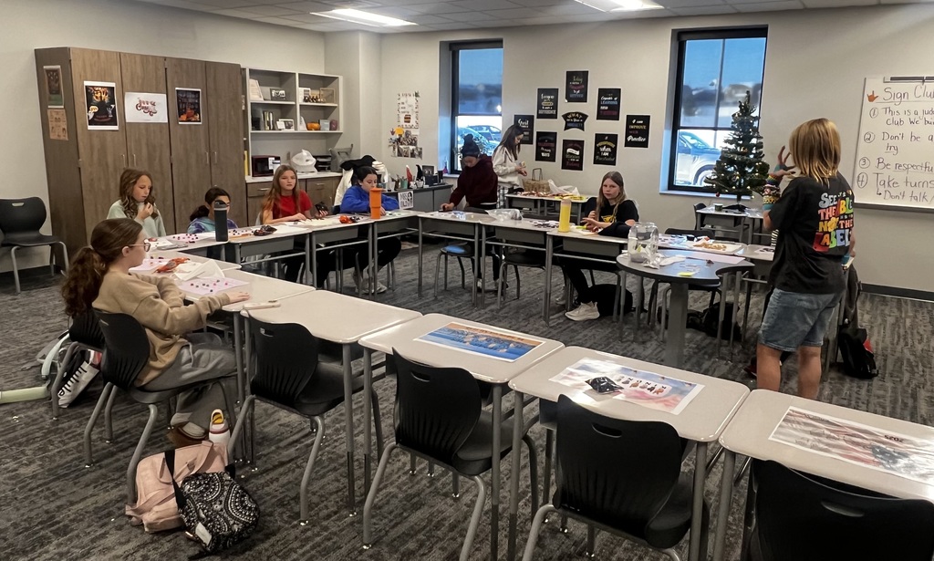 Students sit at desks in a U-shape playing bingo.