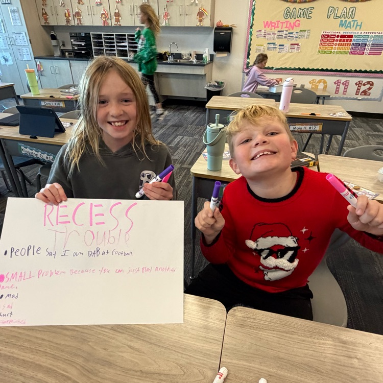 a boy and girl holding up a poster