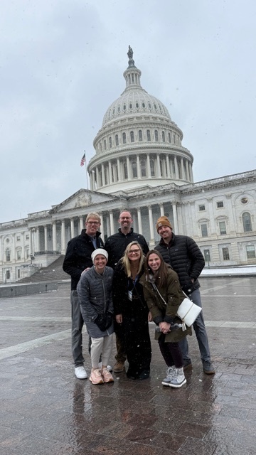 Photo of six social studies teachers standing in front of the Capitol Building. There are three female teachers in front and three male teachers behind them.