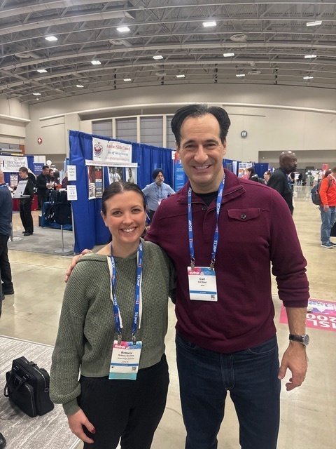 Photo of Mrs. Rindone on the left standing next to Carl Azuz on the right at the social studies convention.