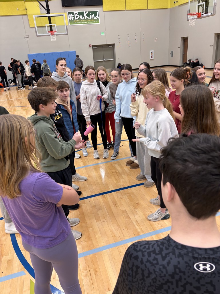 Photo of 7th grade students gathered around a boy and a girl facing off in a rock, paper, scissors battle.