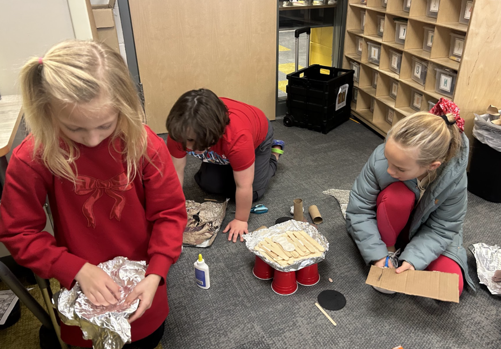 students working on a science project in class of building a boat with materials