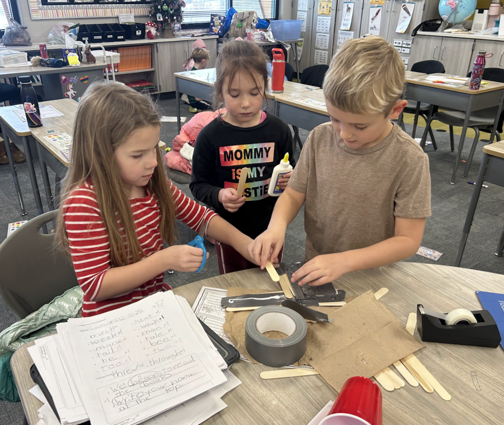 students working on a science project in class of building a boat with materials