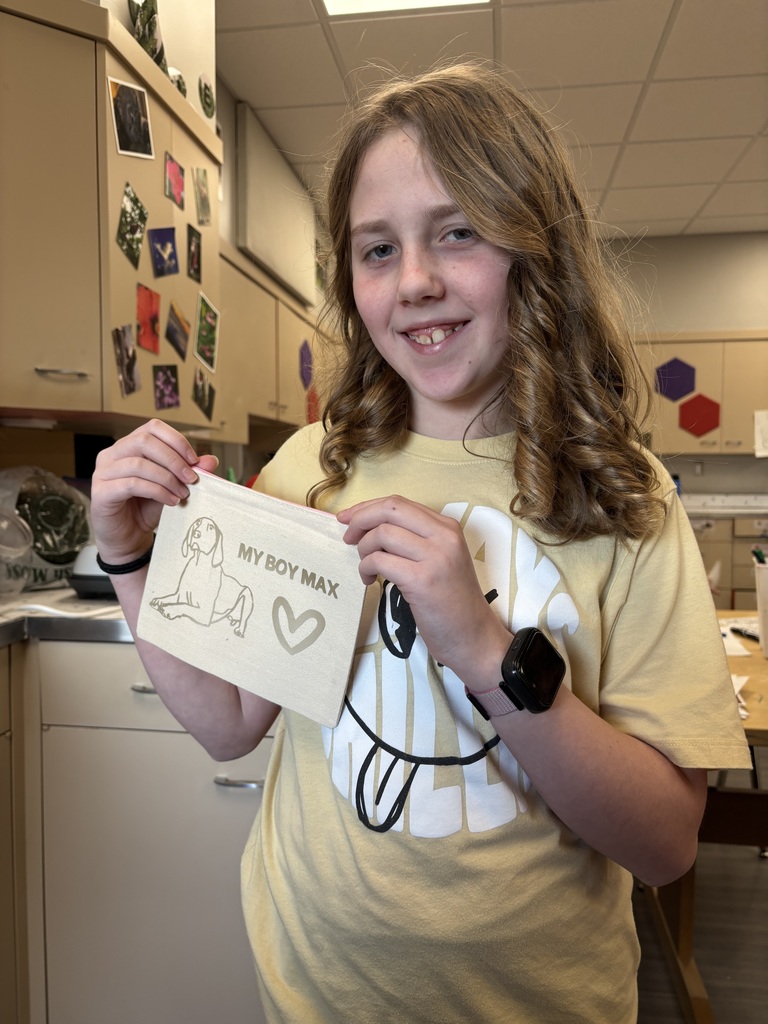 Girl holding a cloth that shows a dog laying down with the words "My Box Max"