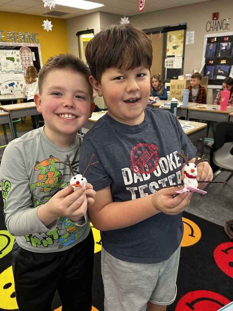 students holding up molded snowmen