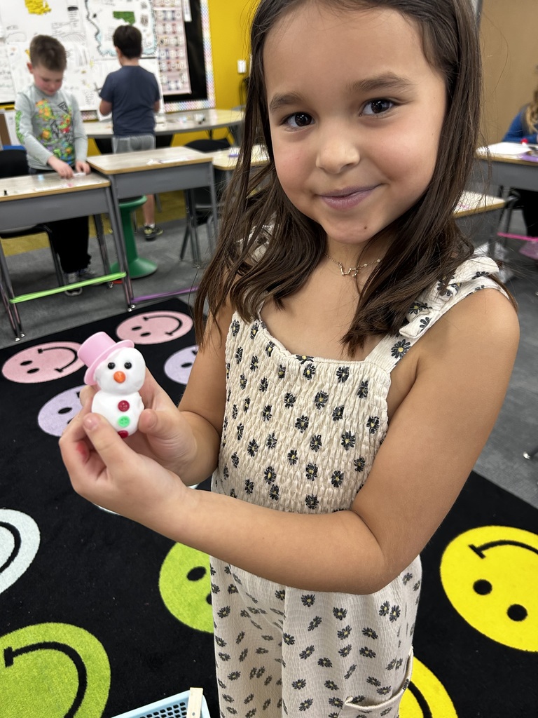 students holding up molded snowmen