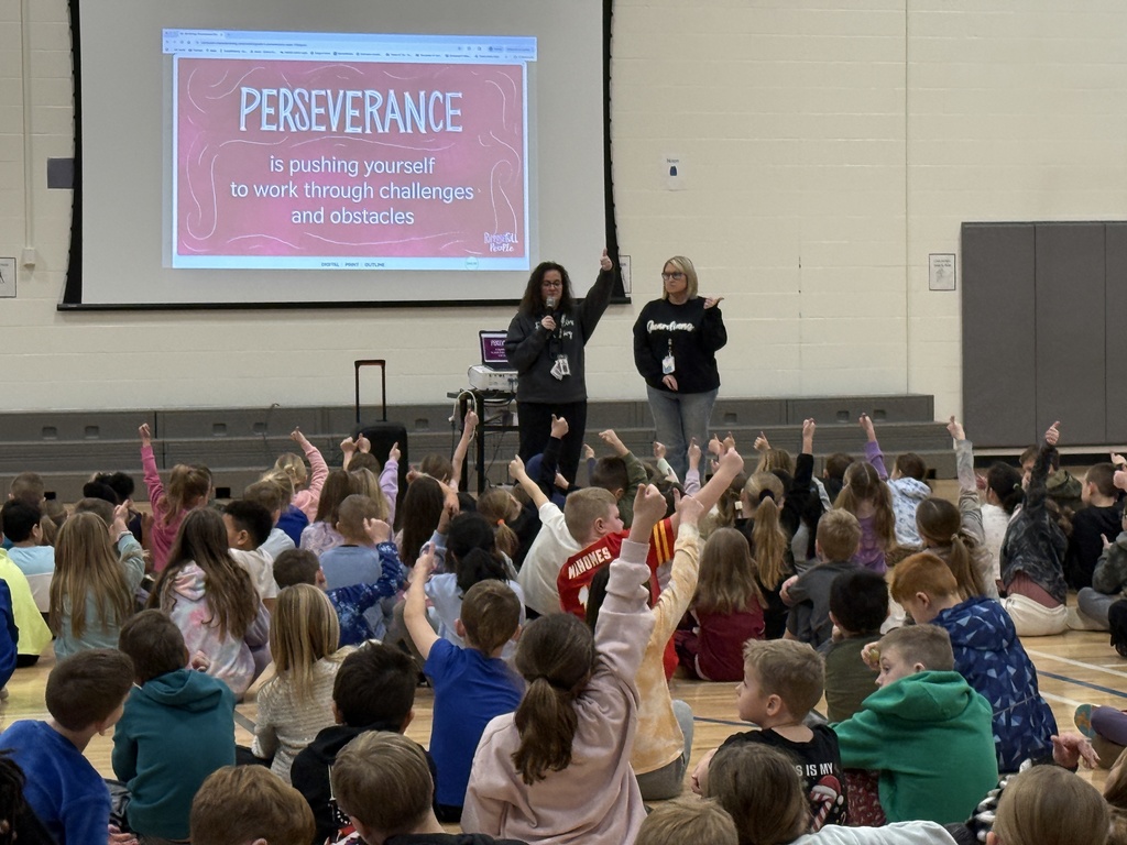 Students and the principal giving a thumbs up they understand and are ready to sho perseverance.