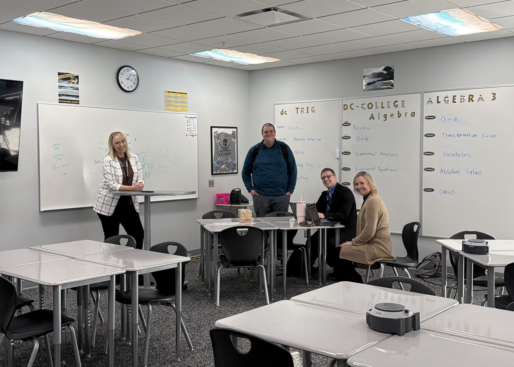 Four GPS Administration staff sitting in classroom waiting for teachers to attend their breakout session during GPS PD Day