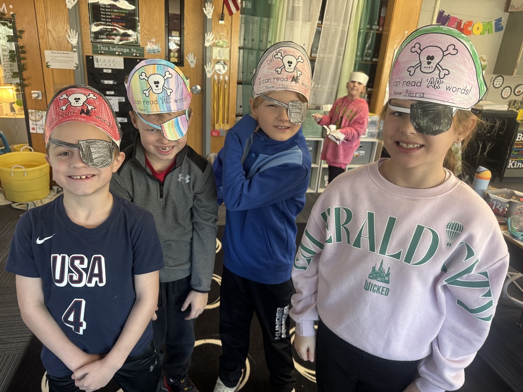 3 boys and 1 girl wearing a pirate hat and a paper eye patch