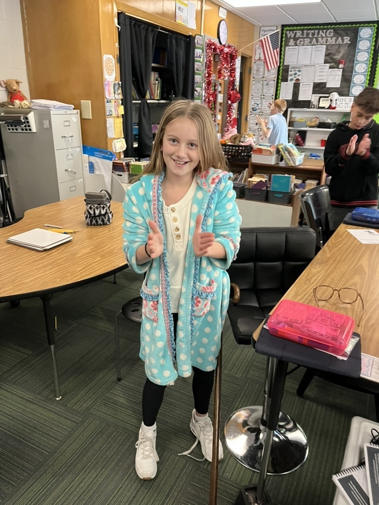 Girl standing and clapping with a group of boys standing in the background
