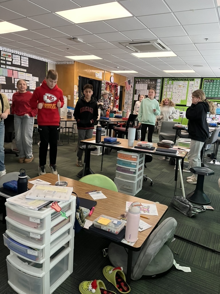 Group of students standing and smiling in a classroom