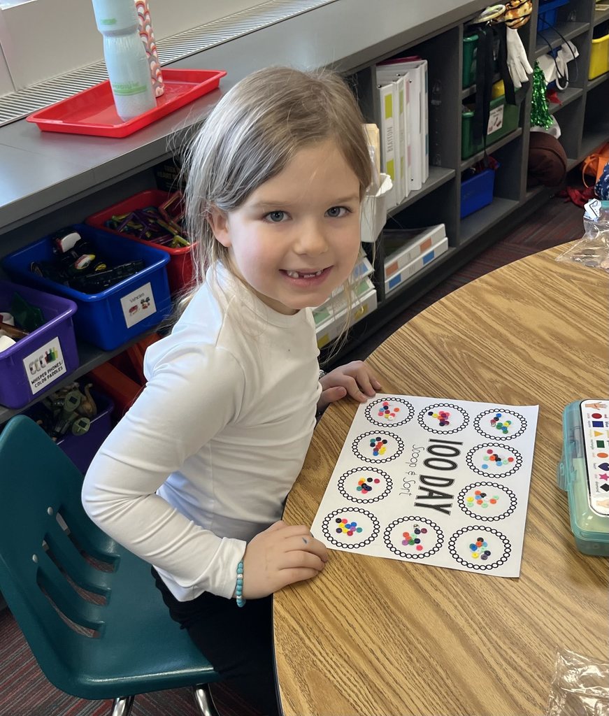 Girl sitting at a table with a 100 day scoop and sort on table