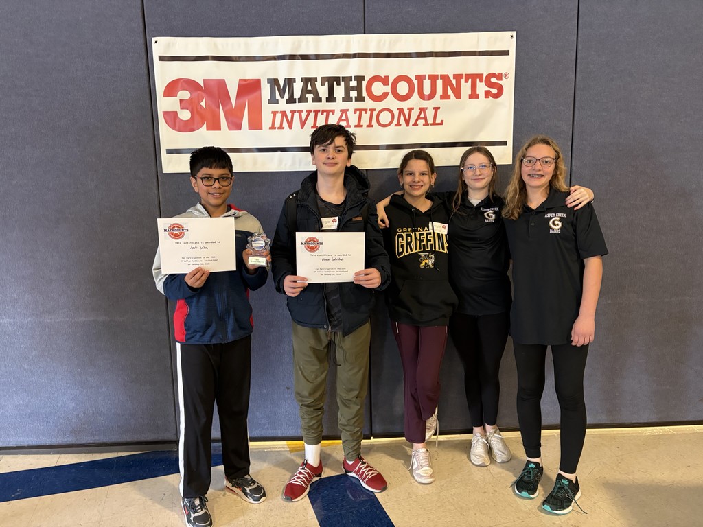 Photo of five students standing in a line. The first two on the left are holding certificates. Behind the students is a sign that says, "3M Math Counts Invitational."