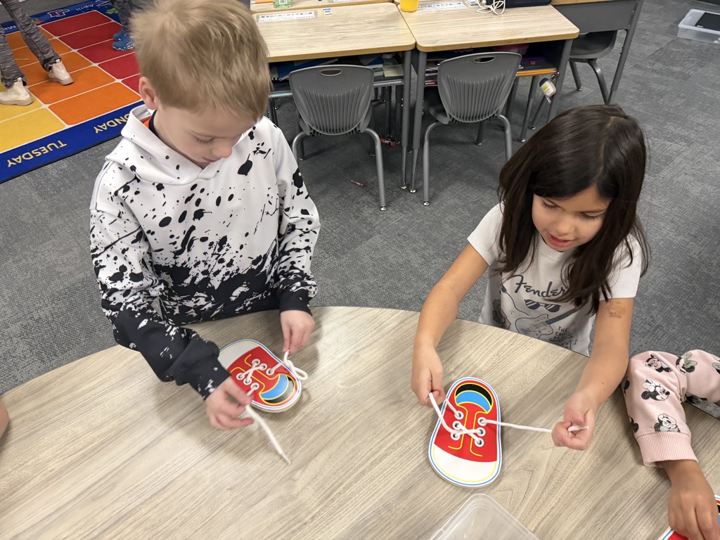 students practicing how to tie shoes in a classroom
